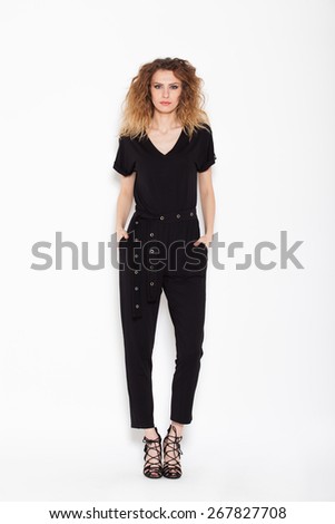 young sexy woman posing in black rompers on white background