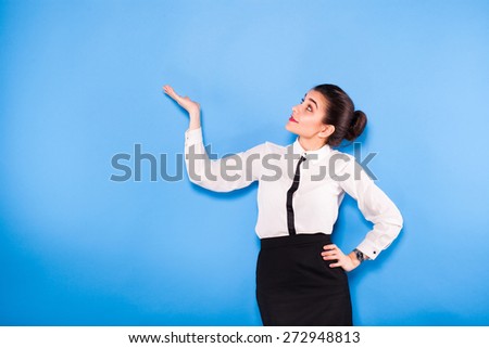 young beautiful woman on office outfit holding something above her head, on blue background