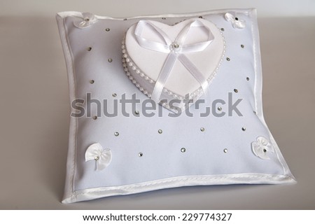 white pillow for wedding rings on the gray background