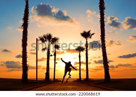 man jumping on skateboard near the ocean in sunset