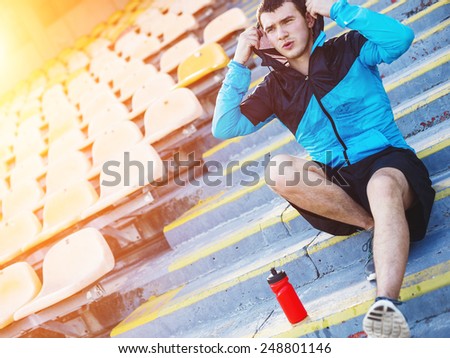tired wet sportsman resting on the stairs