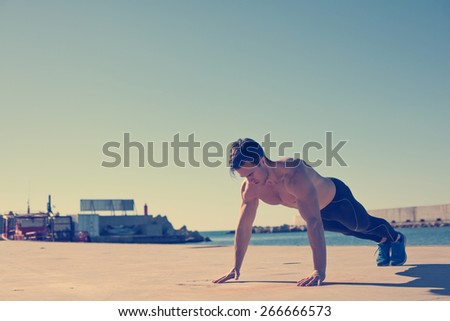 Young athlete doing push-ups outdoors (intentional vintage color)