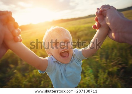 father playing with his son in the park (intentional sun glare and motion blur)