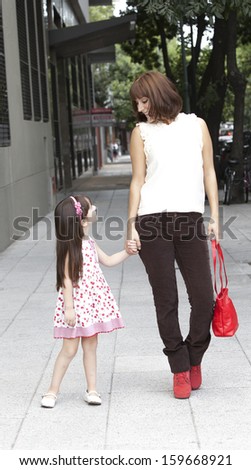 mother and daughter walking in the street