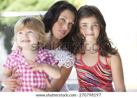 Portrait of mother and two young cute daughters