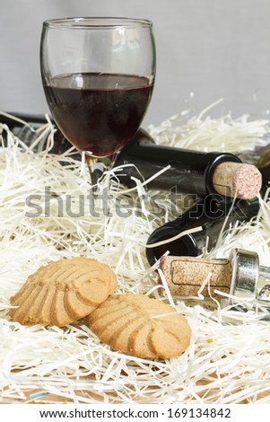 Crackers with glasses of red wine and bottle on fiber paper
