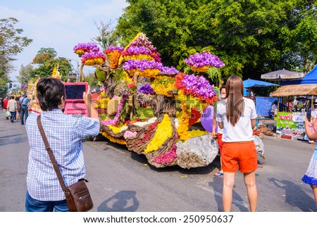 CHIANG MAI,THAILAND-FEBRUARY 08 : People are interested in coming to visit fresh flowers decorate car in annual 39th Chiang Mai Flower Festival,  on February 08, 2015 in Chiang Mai,Thailand.