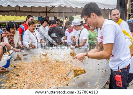 CHIANG MAI, THAILAND - OCTOBER 13: People lap vegetarian food in a large pan during vegetarian food festival as following the traditional Chinese calendar, October 13, 2015 in Chiang mai, Thailand.