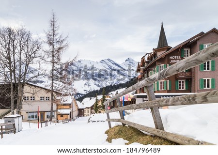 MURREN, SWITZERLAND - DECEMBER 22, 2013: Winter chalets and cabins facing a mountain