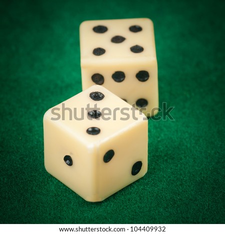 Close up of two dice on a green gaming table