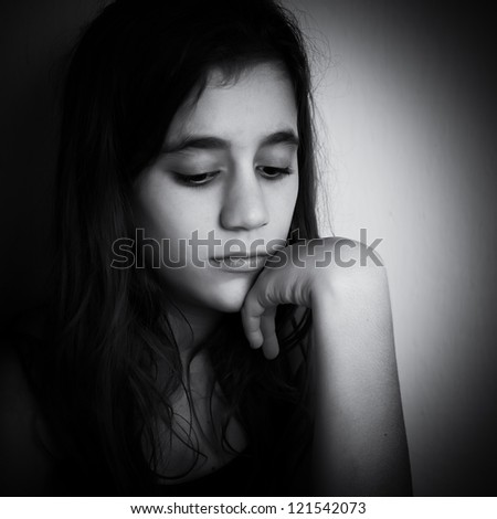 Dramatic black and white portrait of a sad and lonely child