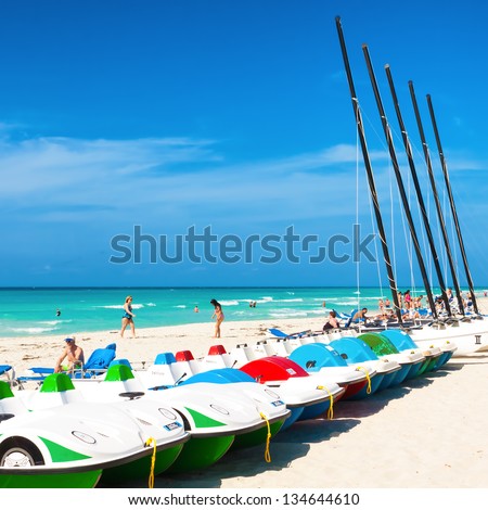 VARADERO,CUBA-APRIL 7:Boats for rent and tourists enjoying the beach April 7,2013 in Varadero.With a growth of 4.5% in 2012,tourism has consolidated as a primary source of income for Cuba