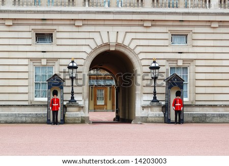 The Royal Guards dressed in their traditional uniforms standing at the gates of Buckingham Palace in London