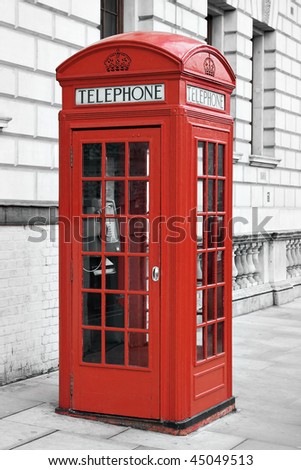 Traditional red telephone booth in London with a desaturated background