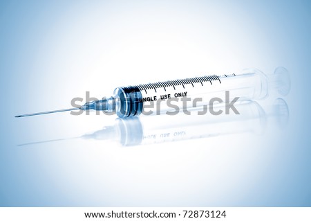 Disposable syringe with refelctions on a blue background