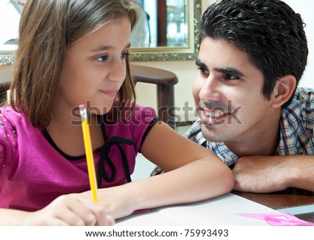 Young latin father helping her daughter with her homework