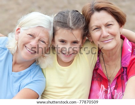 Latin girl hugging her two grandmothers and smiling