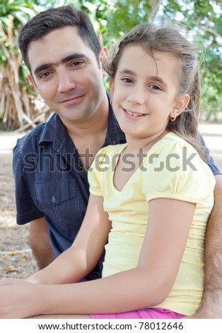 Portrait of a latin father with her daughter at a park
