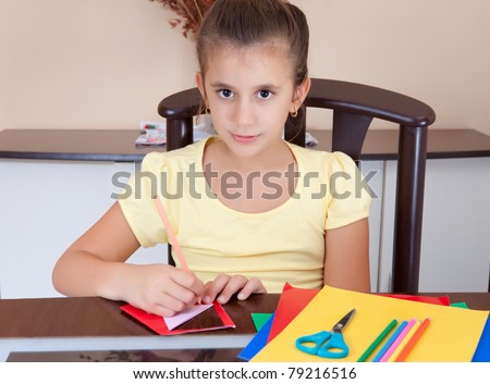 Beautiful latin girl working on her art project at home with some art supplies on the table