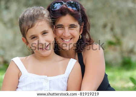 Portrait of a beautiful latin mother and daughter in a park