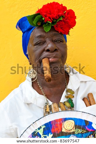 HAVANA-JUNE 29:Old black lady with a fine cigar June 29, 2011 in Havana. The african culture and religions have a huge influence in Cuba where approximately 50% of the population is of african descent