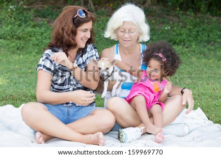 Happy latin family camping on a park (including grandmother, mother, daughter and a small dog)