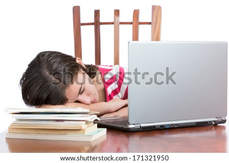 Tired student sleeping on her desk with a laptop computer and books (isolated on white)