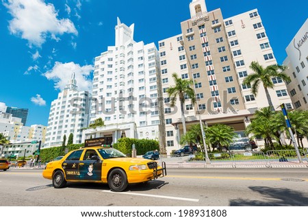 MIAMI,USA - MAY 20,2014 : Famous art deco hotels and traffic  at Collins Avenue on a sunny day at Miami Beach