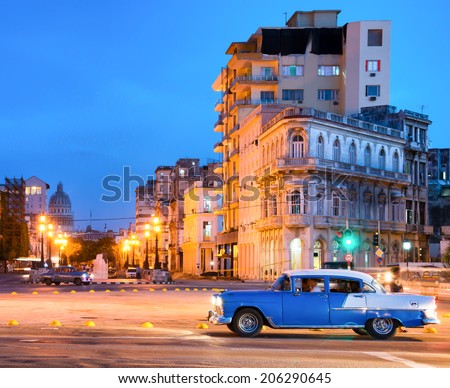 HAVANA,CUBA - JULY 9, 2014 : Urban scene at night in Old Havana with a view of a classic american car and  the street lamps and old buildings near El Prado