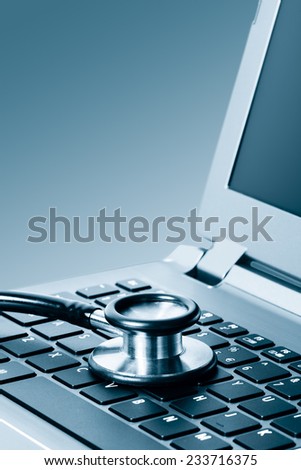Computer or data analysis - Stethoscope over a laptop computer keyboard toned in blue