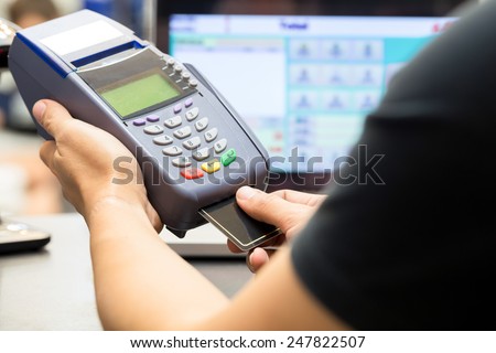 man\'s hand with credit card swipe through terminal for sale in store