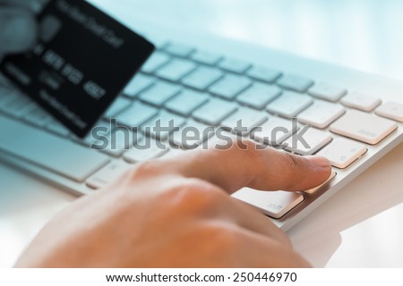 hand holding a credit card and typing. On-line shopping on the internet