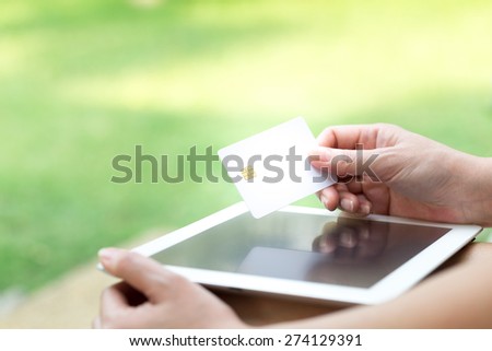 Woman\'s Hands Holding A Credit Card And Using Tablet PC. Online Shopping Concept