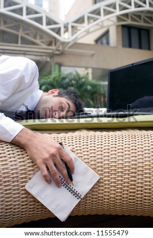 Man in business attire passed out in front of his laptop