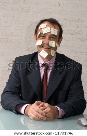 Latin american business executive sitting in an office using post-it notes to stay organized
