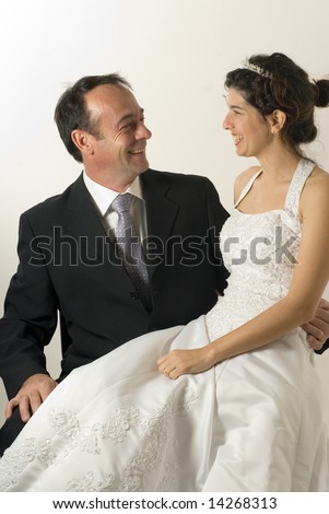 Newly weds, smile at each other. The wife sits on husbands lap. - vertically framed