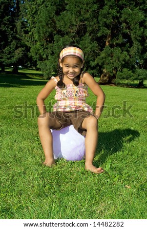Happy little girl on a bouncy ball - Horizontally framed photograph.