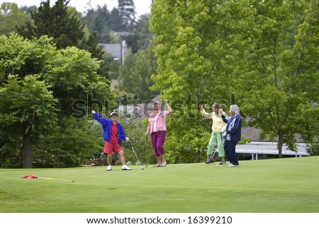 Group of four women celebrating while playing golf. Horizontally framed photo.