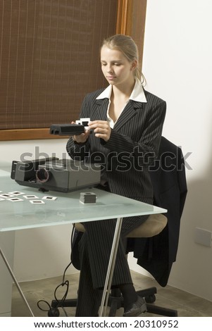 Woman  placing slides in  a slide show projector. Vertically framed photo.