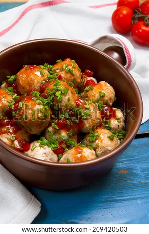 Turkey meatballs with tomato sauce and chives onion in a ceramic pan