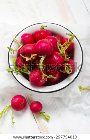 Red raw radishes in an old white bowl