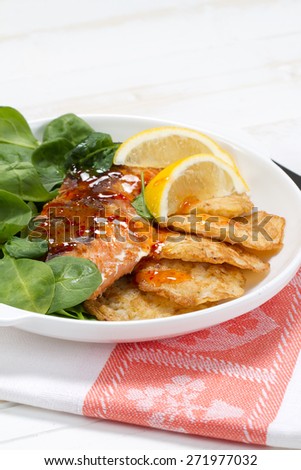 Baked coho salmon, rice pancakes, lemon and young spinach leaves