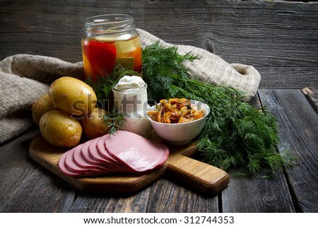 Traditional Siberian food: potatoes, ham, pickled vegetables, marinated mushrooms, dill and sour cream