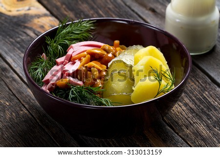 Traditional Siberian salad: boiled potatoes, ham, pickles, marinated mushrooms, dill and sour cream