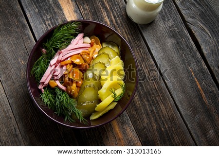 Traditional Siberian salad: boiled potatoes, ham, pickles, marinated mushrooms, dill and sour cream