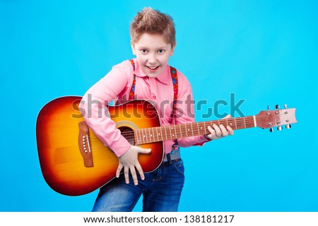 portrait of a boy with guitar on the blue background