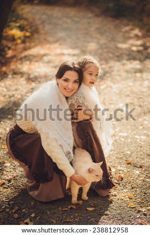 Mother and her daughter in vintage clothes with a cat