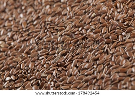 Brown flax seed background. Flax seed is a good source of omega-3 fatty acids, can aid in digestion, and is used to make linseed oil. The plants are used to make linen.