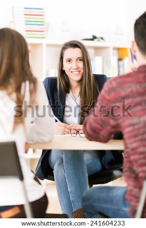 Young woman working at her desk with clients