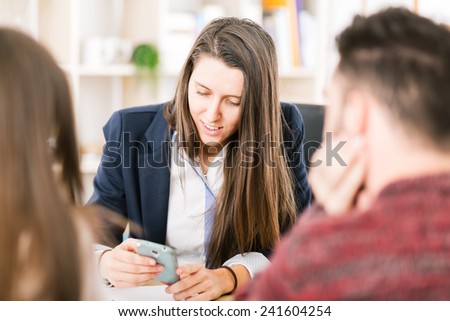 Young woman working at her desk with clients